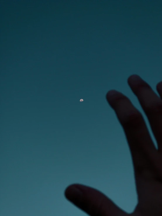 a close up of a person's hand with the moon in the background, inspired by Elsa Bleda, unsplash, postminimalism, ufo in the sky, low quality photo, pointing, up there