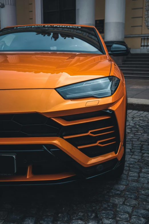 an orange sports car parked in front of a building, pexels contest winner, renaissance, macro up view metallic, square, trending on unreal engine, with cool headlights