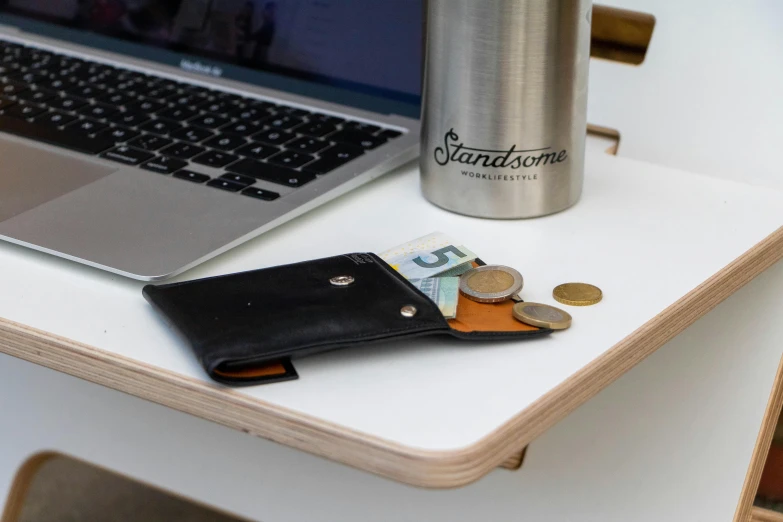 a wallet sitting on top of a table next to a laptop, by Android Jones, on a wooden tray, subsurface scandering, cash on a sidetable, thin button nose