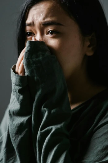 a woman covers her face with her hands, inspired by Yu Zhiding, pexels contest winner, long sleeves, cry engine, side profile portrait, asian face