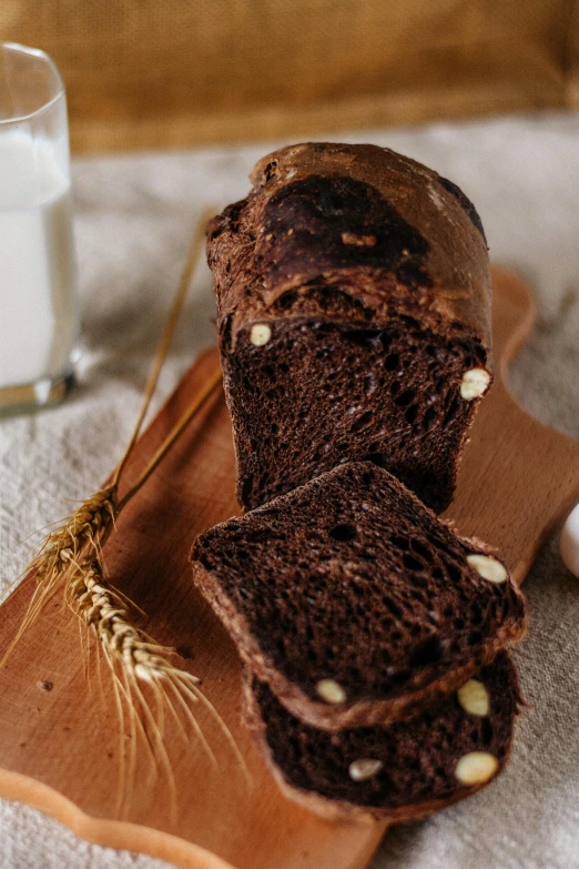 a loaf of bread on a cutting board next to a glass of milk, a portrait, by Franz Hegi, unsplash, fully chocolate, brocade, corn, malaysian