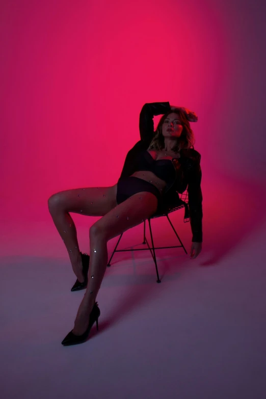 a woman sitting on top of a chair, an album cover, inspired by Elsa Bleda, trending on pexels, holography, pink body, sexy pose, high red lights, sydney sweeney