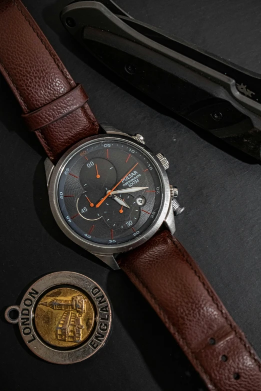 a watch sitting on top of a table next to a knife, a portrait, thumbnail, feature, cinematic front shot, vehicle