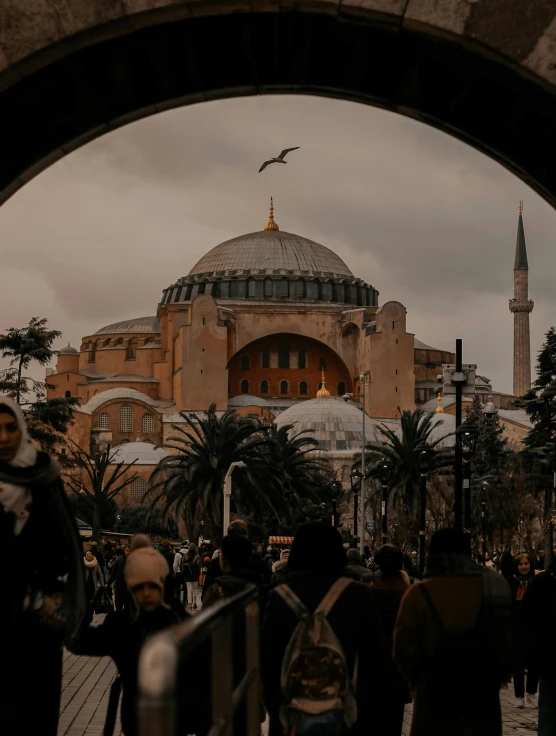 a group of people standing in front of a building, by Ismail Acar, pexels contest winner, hurufiyya, with great domes and arches, 🚿🗝📝, black and terracotta, gif