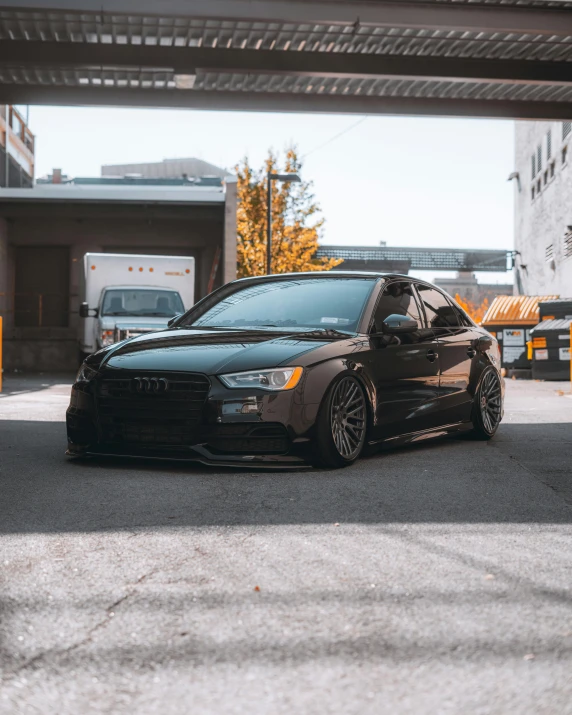a black car parked in a parking garage, by Adam Rex, epic stance, low quality photo, audiophile, modded