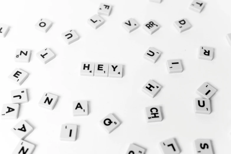a bunch of letters sitting on top of a white surface, a photo, by Emma Andijewska, pexels, letterism, hey, made of all white ceramic tiles, hello, black color on white background