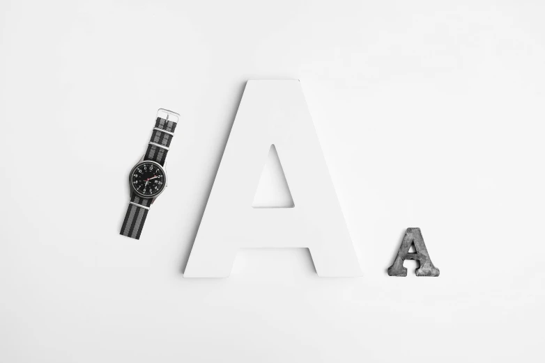 a black and white photo of a watch next to the letter a, a stipple, unsplash, letterism, design on white background, white and black clothing, high quality wallpaper, various posed