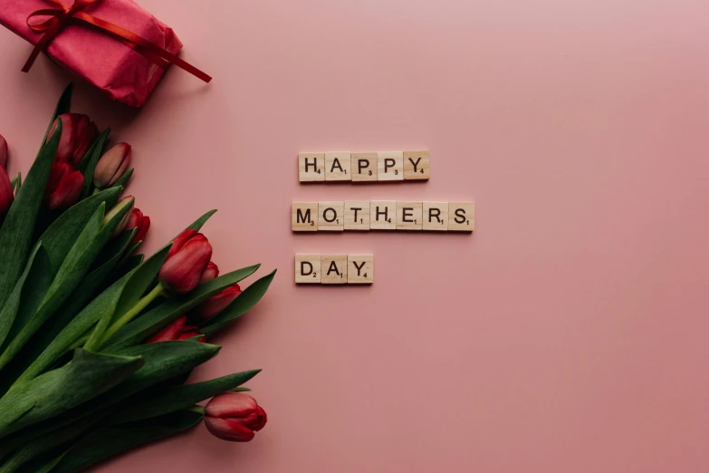 a bouquet of tulips and a wooden block that says happy mothers's day, by Carey Morris, pexels contest winner, hurufiyya, avatar image, pink and red colors, ladies, alternate angle