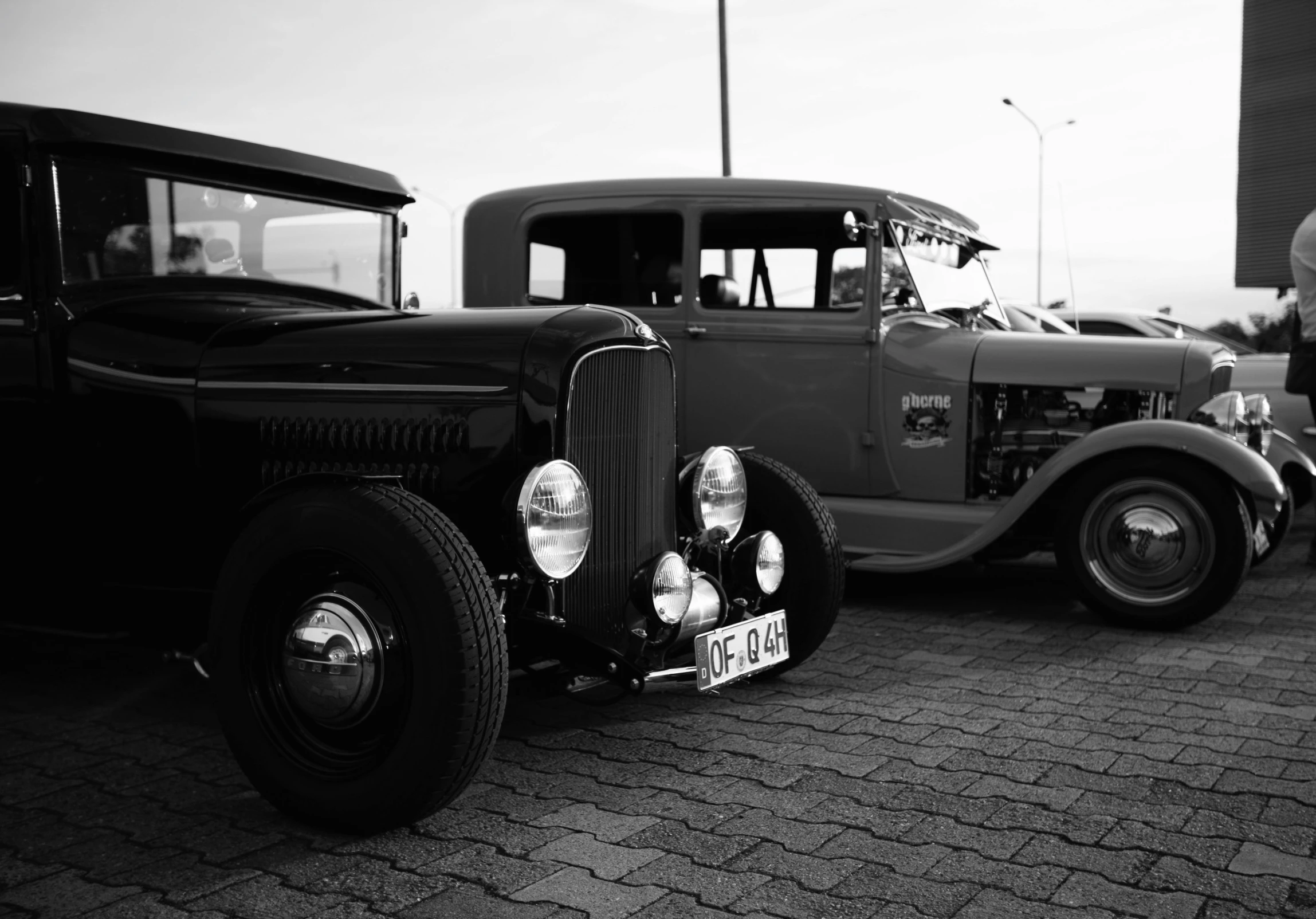 a couple of old cars parked next to each other, a black and white photo, by Jaakko Mattila, unsplash, lowbrow, driving a hotrod, square, ford, 1930 photo