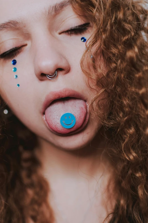 a girl with long curly hair sticking out her tongue, inspired by Elsa Bleda, trending on pexels, antipodeans, pierced navel, dayglo blue, belly button showing, shaved face