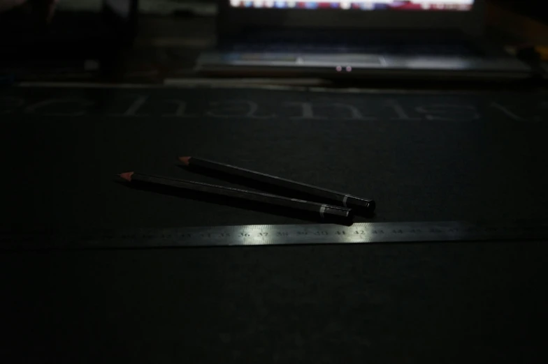 an open laptop computer sitting on top of a desk, a drawing, by Pablo Rey, unsplash, hyperrealism, pencils, standing with a black background, spears, 2 0 0 0's photo