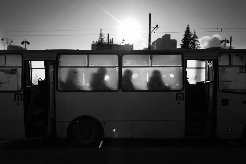 a black and white photo of people boarding a bus, by Jan Rustem, sunset backlight, azamat khairov, blank, resting