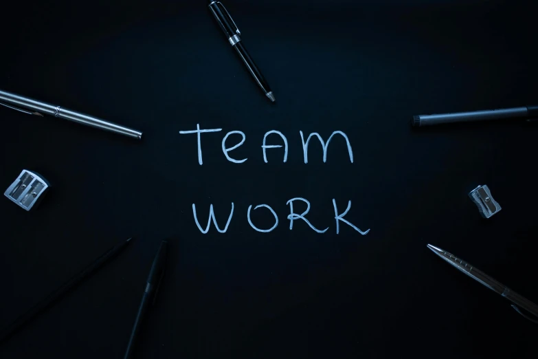 a blackboard with the words team work written on it, unsplash, blue ballpoint pen, dark. no text, background image, profile picture