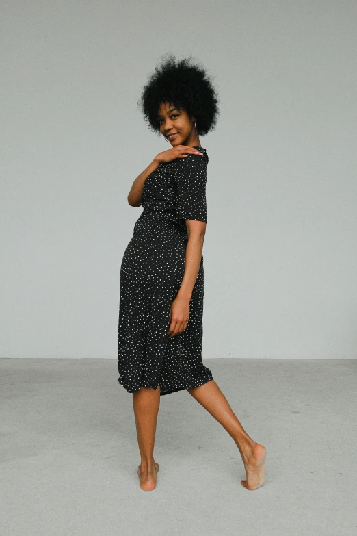 a woman in a black and white dress posing for a picture, inspired by Esaias Boursse, unsplash, dots, young black woman, square, half turned around