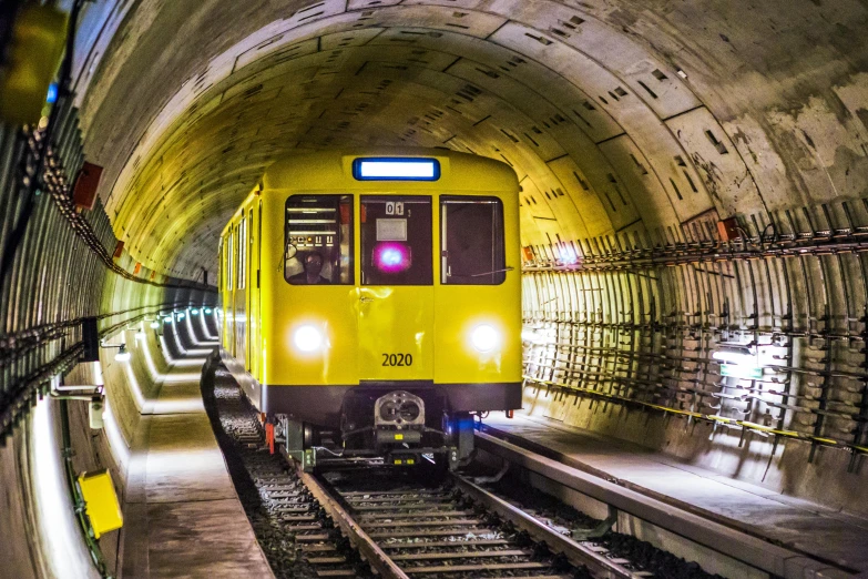 a yellow train is coming out of a tunnel, a portrait, flickr, demur, underground facility, 2022 photograph, getty images