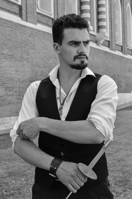 a black and white photo of a man holding a knife, a black and white photo, inspired by Carlo Mense, reddit, renaissance, wearing waistcoat, tony stark, publicity cosplay, handsome man