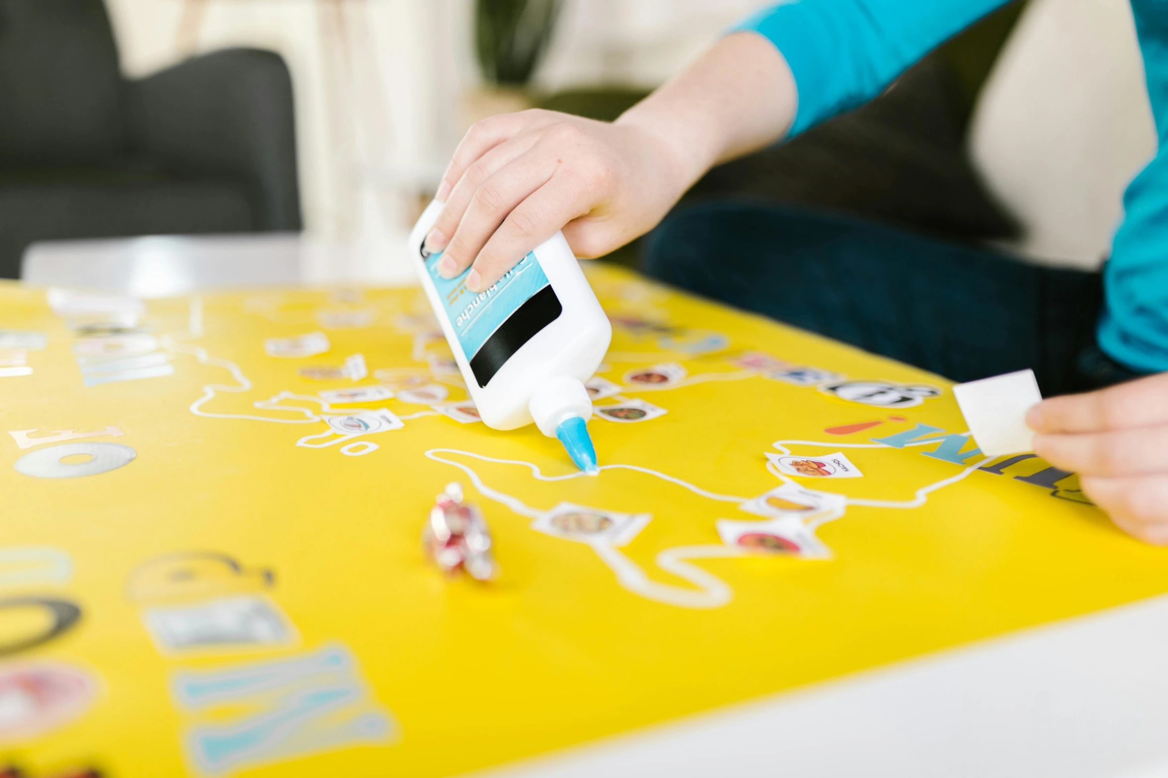 a close up of a person using a cell phone on a table, board game, toothpaste blast, white finish, white ink