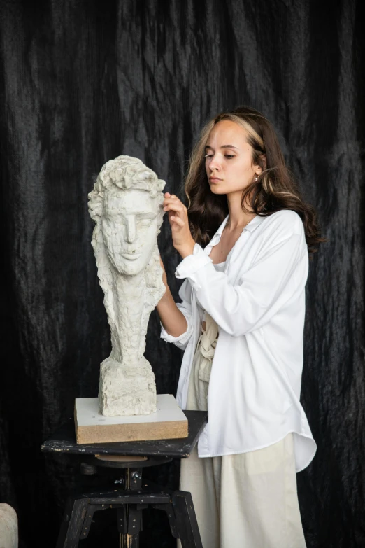 a woman standing next to a statue of a woman, a marble sculpture, inspired by Gian Lorenzo Bernini, academic art, wearing lab coat and a blouse, girl creates something great, head and shoulder portrait, dasha taran