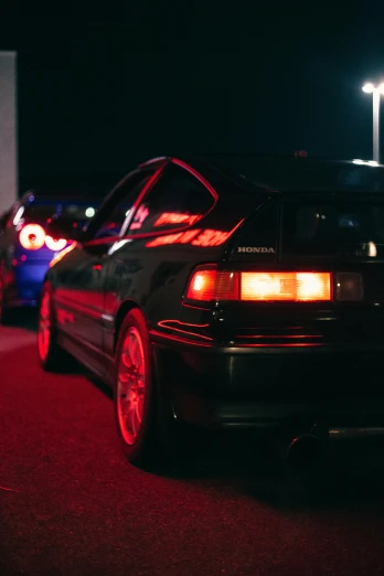a car parked in a parking lot at night, jdm, lit from behind, festivals, left profile