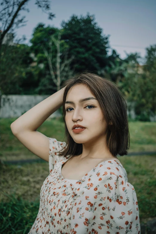 a woman standing in a field with her hand on her head, inspired by Elsa Bleda, pexels contest winner, realism, young cute wan asian face, square face, 8k selfie photograph, short - medium length hair