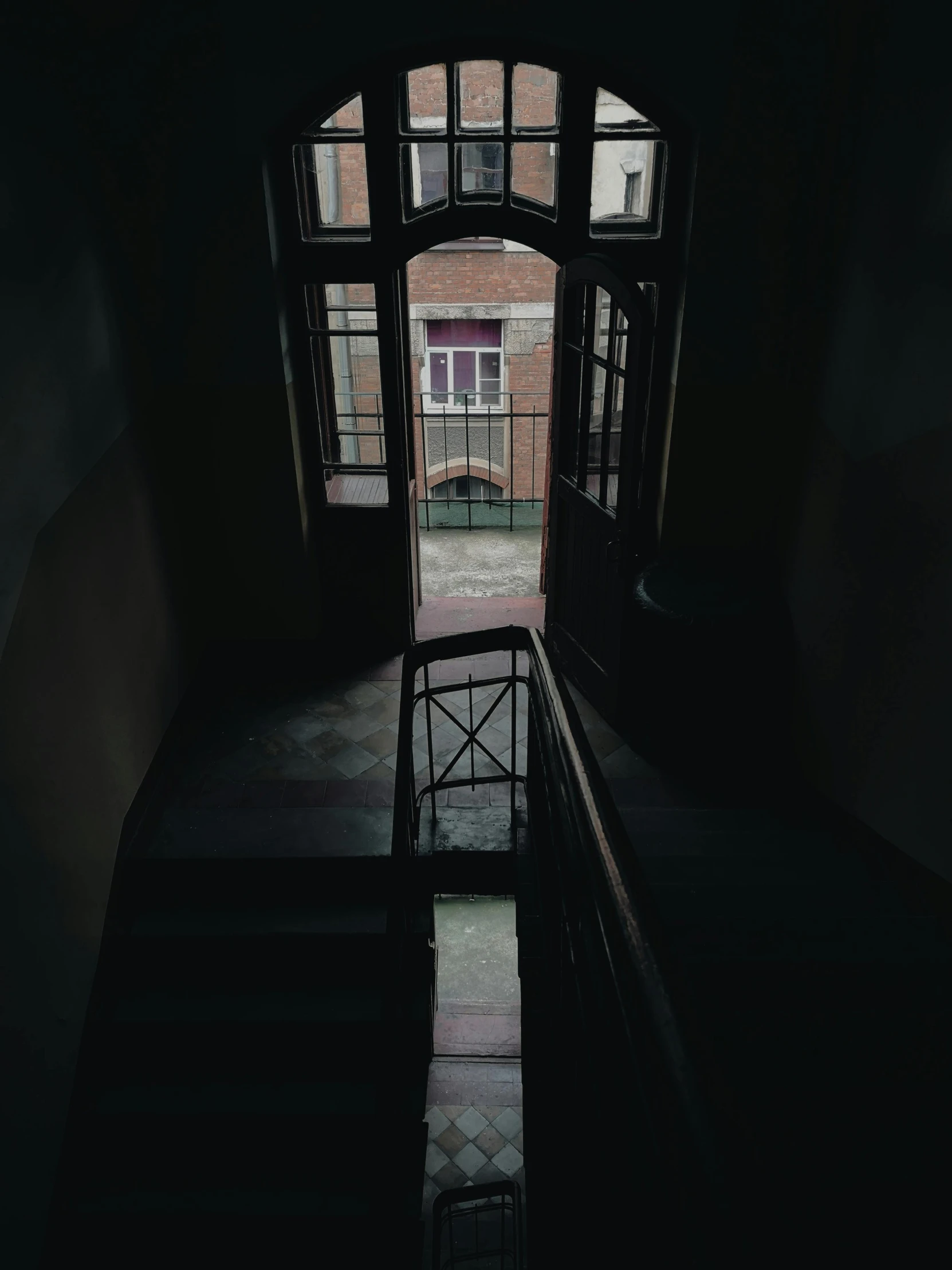 a chair sitting in the middle of a dark hallway, inspired by Elsa Bleda, pexels contest winner, art nouveau, highrise made up staircases, view from window, post - soviet courtyard, low quality photo