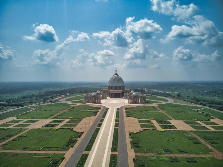 a large building sitting on top of a lush green field, by Matthias Stom, pexels contest winner, bengal school of art, mausoleum, sky view, dome, alvaro siza
