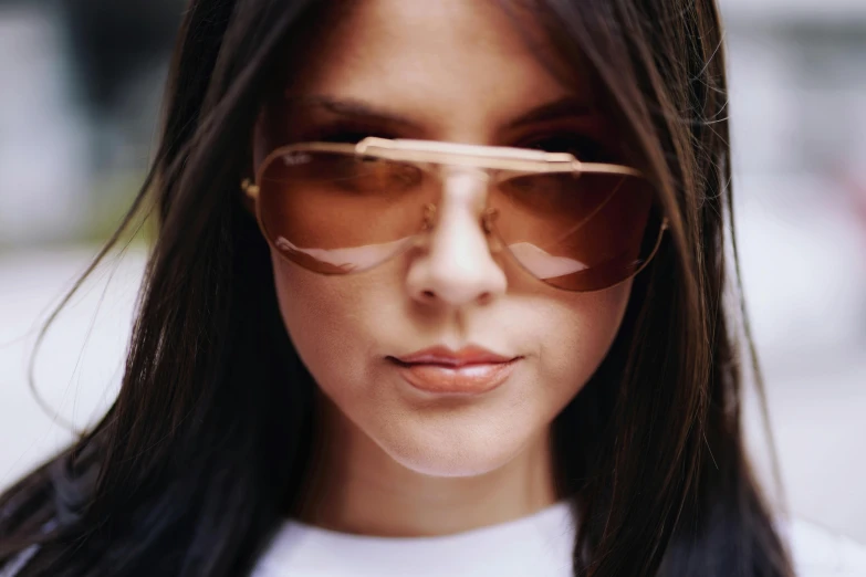 a close up of a person wearing sunglasses, inspired by Elsa Bleda, trending on pexels, girl with dark brown hair, in shades of peach, orelsan, fan favorite