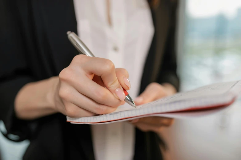 a woman holding a pen and writing on a piece of paper, pexels, private press, royal commission, instagram photo, formal attire, thumbnail