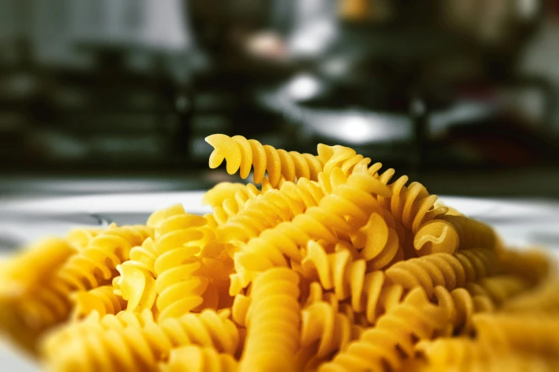 a pile of pasta sitting on top of a white plate, a macro photograph, by Carey Morris, trending on pexels, bolts of bright yellow fish, steaming food on the stove, spiralling, thumbnail