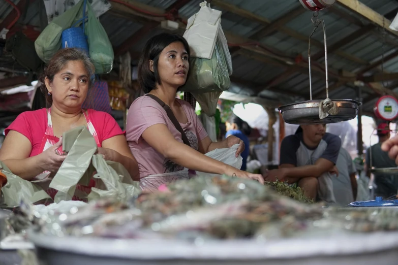 a couple of women standing next to each other, by Meredith Dillman, sumatraism, fish seafood markets, avatar image, manila, concerned