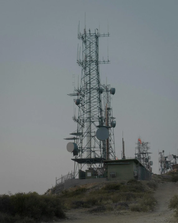 a group of cell towers sitting on top of a hill, by Alejandro Obregón, no cropping, grey, sparsely populated, lgbtq