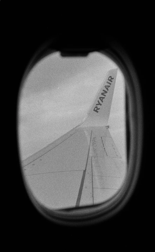 a view of the wing of an airplane through a window, a black and white photo, flickr, renaissance, vhs footage still, a round minimalist behind, tail fin, ears