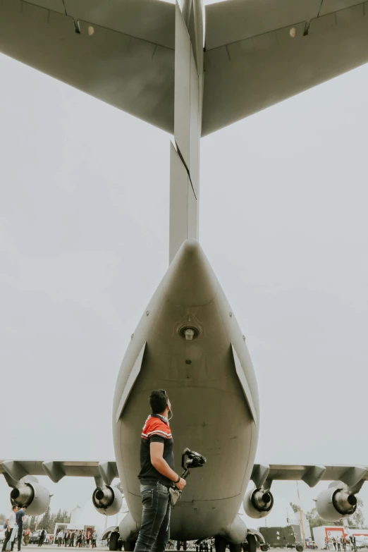a man standing in front of a large airplane, by Paul Bird, pexels contest winner, hercules brabazon, down there, avatar image, maintenance photo
