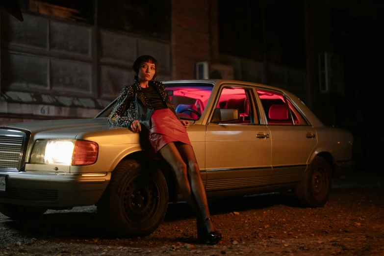 a woman sitting on the hood of a car, an album cover, inspired by Elsa Bleda, pexels contest winner, neon lighting medium full shot, mercedes, in style of nan goldin, promotional image