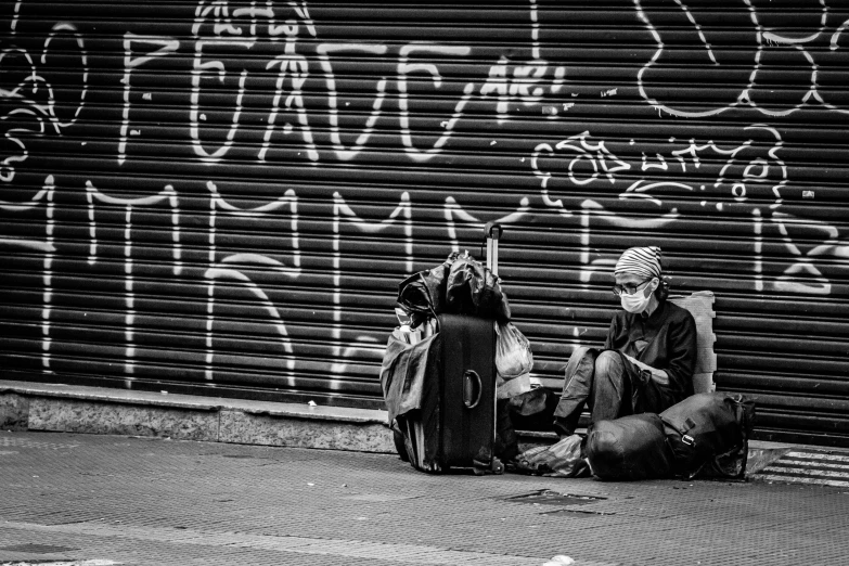 a couple of people sitting on the side of a street, a photo, by Lucia Peka, pexels, street art, donald trump as a homeless man, bags on ground, dusty abandoned shinjuku, covid-19 as a human