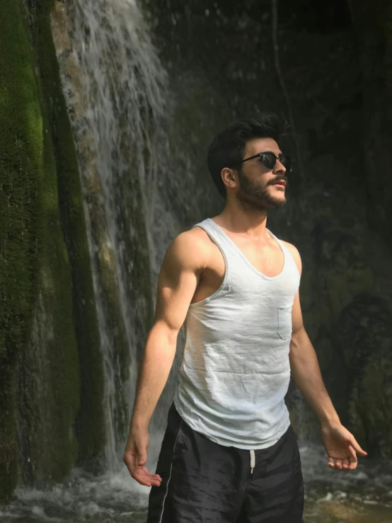 a man standing in front of a waterfall, by Adam Dario Keel, wearing a tanktop, farid ghanbari, profile image, profile pic