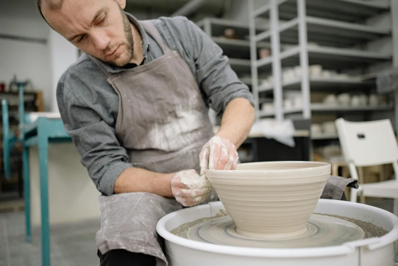 a man is making a bowl out of clay, a portrait, inspired by Hendrik Gerritsz Pot, unsplash, man wearing a closed cowl, 15081959 21121991 01012000 4k, lachlan bailey, big production