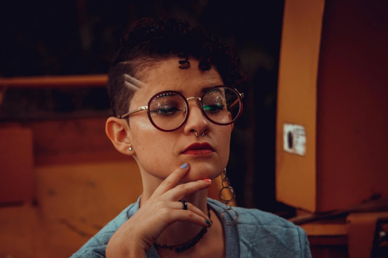 a close up of a person wearing glasses, a portrait, inspired by Elsa Bleda, trending on pexels, antipodeans, curly pixie cut hair, smoking woman, shaved sides, half - length photo