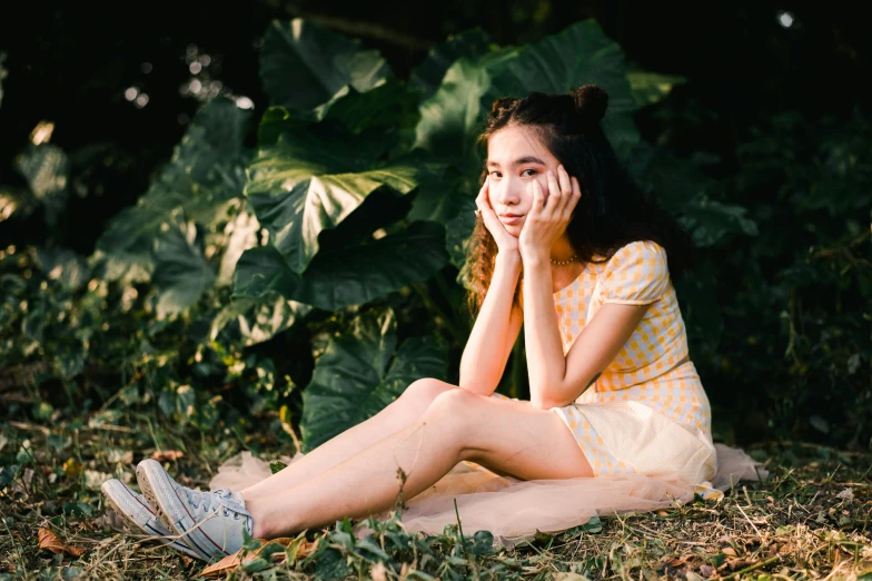 a woman sitting on the ground talking on a cell phone, by Juliette Leong, pexels contest winner, portrait of a cute girl, lush surroundings, young cute wan asian face, avatar image