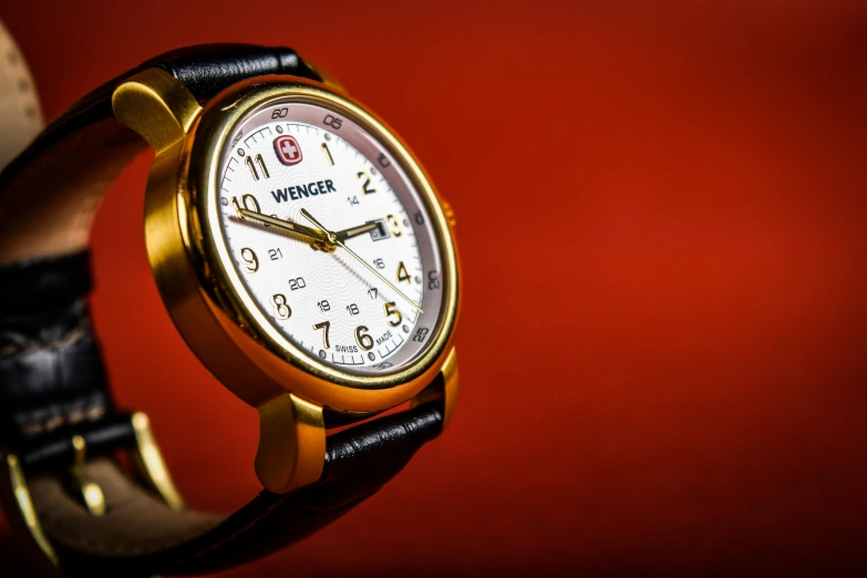 a close up of a wrist watch with a red background, inspired by Eugène Brands, photorealism, vintage - w 1 0 2 4, gold and white, medic, medium shot angle