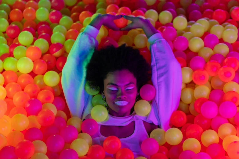 an image of a woman in a ball pit, inspired by David LaChapelle, pexels, process art, neon accent lights, ( ( dark skin ) ), laying down, instagram photo