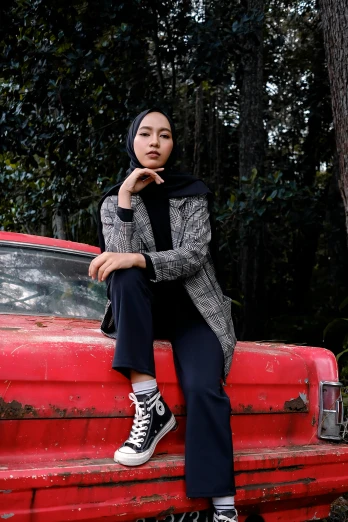 a woman sitting on top of a red truck, a picture, by Basuki Abdullah, pexels contest winner, hurufiyya, wearing a blazer, lookbook, with black, flannel