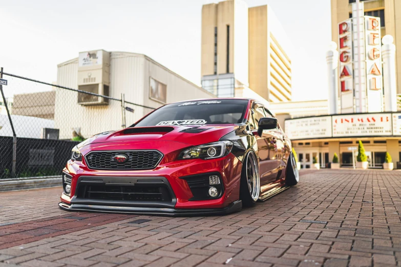 a red car parked in front of a movie theater, a portrait, inspired by An Gyeon, unsplash, auto-destructive art, subaru, long front end, samurai vinyl wrap, brown