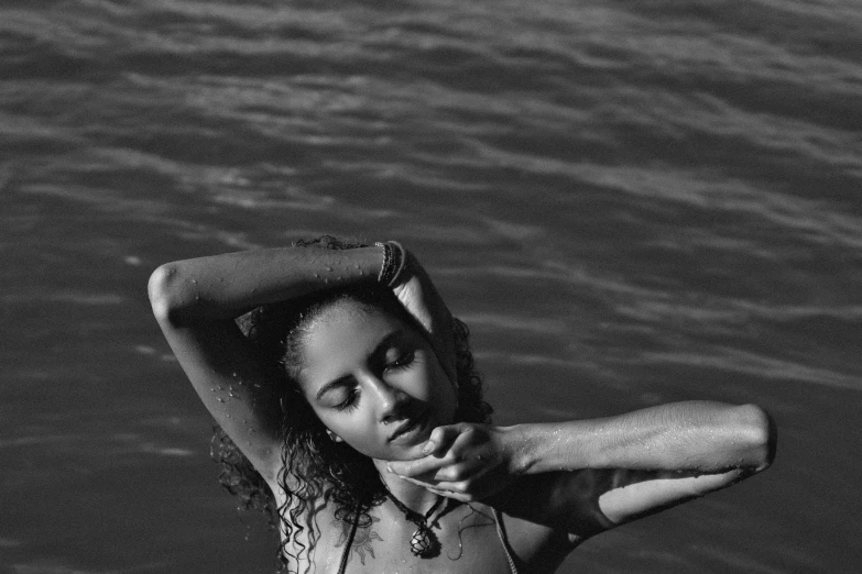 a black and white photo of a woman in the water, vanessa morgan, brown skinned, sun lit, various posed