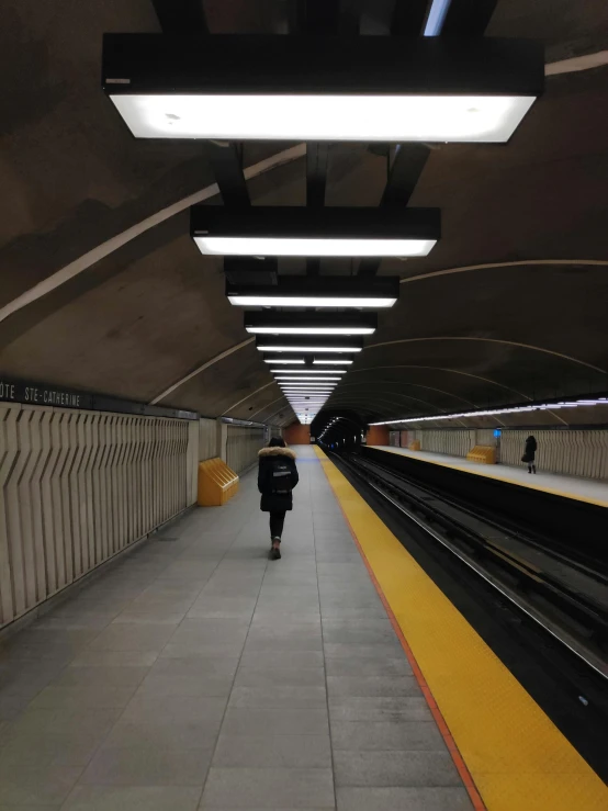 a subway station with a person walking on the platform, the city of toronto, profile image