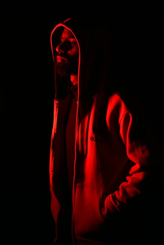 a man in a hoodie standing in the dark, by Greg Staples, volumetric lighting. red, high resolution print :1 red, nipsey hussle, high key lighting