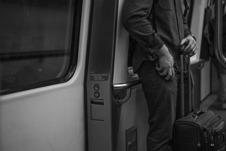 a black and white photo of a man standing on a train, unsplash, figuration libre, washington dc, hiding, gray men, holding arms on holsters