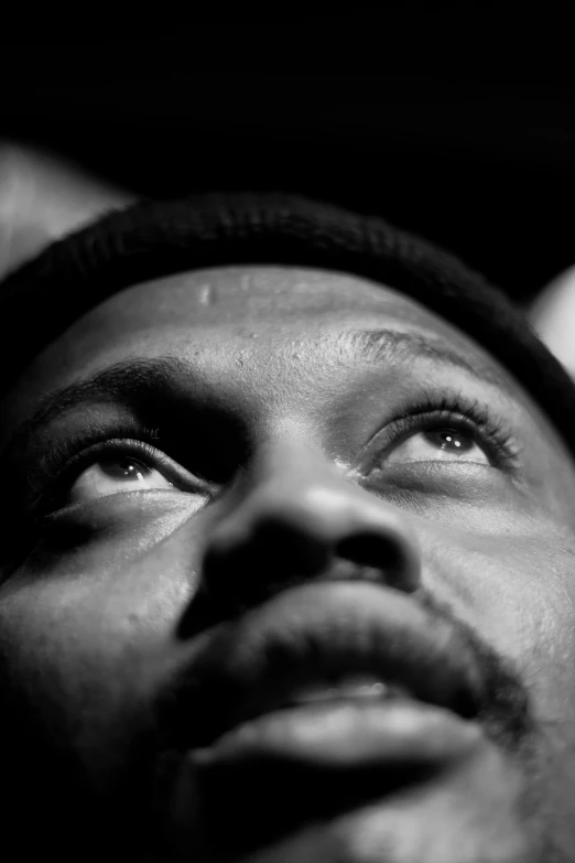 a black and white photo of a man looking up, by Dave Melvin, ice cube, aubrey powell, numerous dimly glowing eyes, alphonse muca