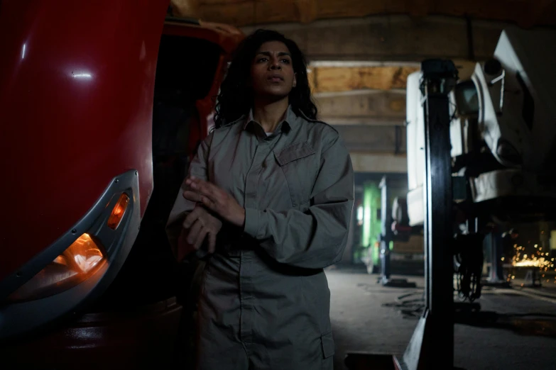 a woman standing next to a red truck, a portrait, pexels, dau-al-set, in a darkly lit laboratory room, mia khalifa, from the tusk movie, mechanic