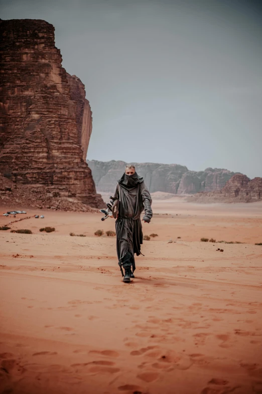 a man standing in the middle of a desert, inspired by ridley scott, pexels contest winner, les nabis, wear spacesuits, leather robes, wadi rum, man walking